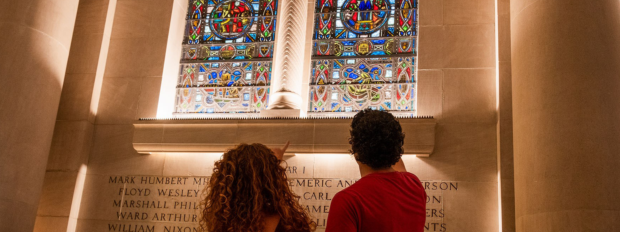 Two students looking at the names engraved in the Gold Star Hall