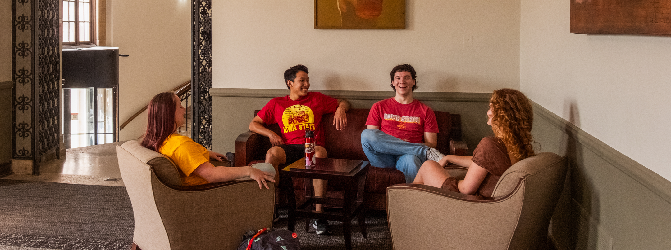 Four students hanging out and talking in the West Lounge
